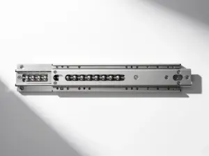 Ausgefahrene Edelstahl-Teleskopschiene mit sichtbaren Kugellagern im Gleitlager, Draufsicht auf weißem Untergrund.